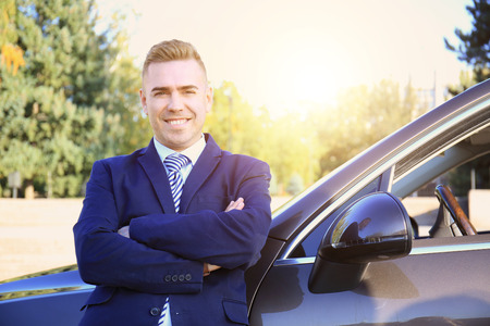Man in formal wear standing near car on city streetの写真素材