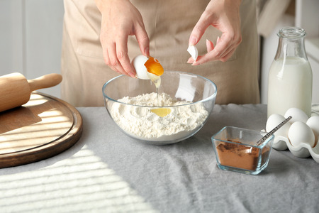 Woman preparing dough for cinnamon buns in kitchen