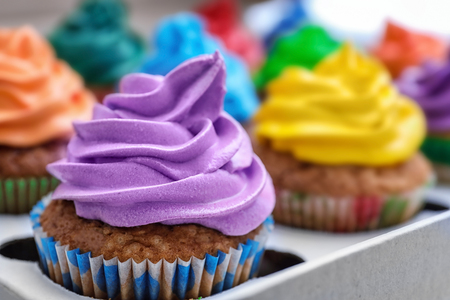Tasty colorful cupcakes in box, close up