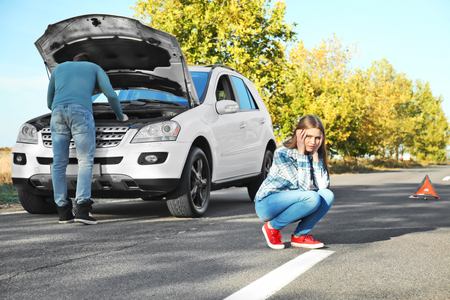 Young couple near broken car outdoorsの写真素材
