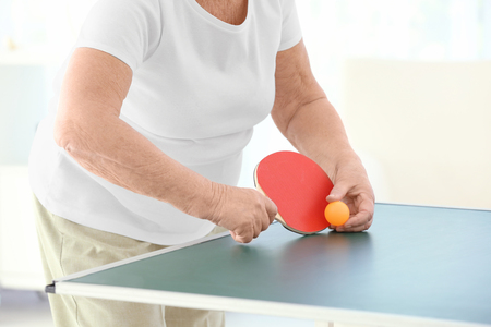 Senior woman playing table tennis indoorsの写真素材