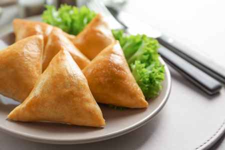 Plate with delicious baked samosas on table, closeupの写真素材