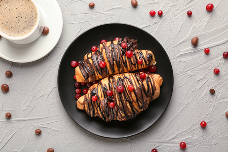 Plate with tasty croissants and cup of coffee on tableの写真素材