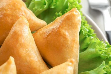 Plate with delicious baked samosas, closeup