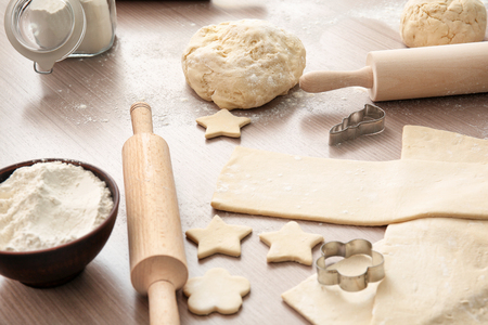 Raw puff pastry with forms on tableの写真素材