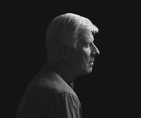 Portrait of handsome mature man on dark backgroundの写真素材