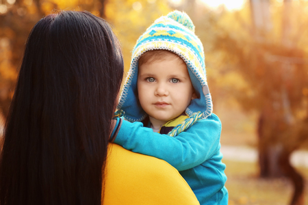 Cute little child with mother in autumn parkの写真素材