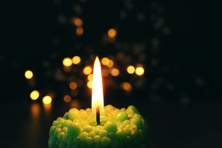Beautiful bubble candle burning on festive lights background, closeupの写真素材