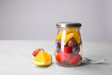 Delicious fruit salad in jar on tableの写真素材