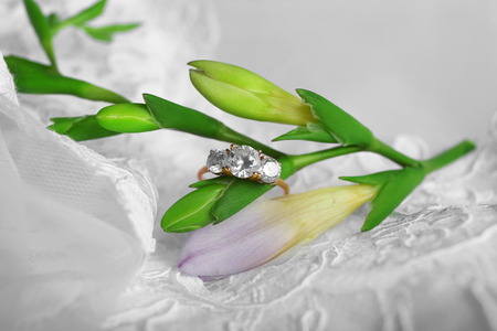Beautiful engagement ring and flower on laceの写真素材