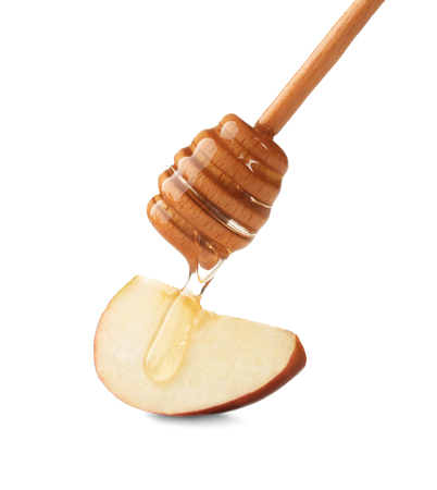 Pouring aromatic honey onto slice of apple against white backgroundの写真素材