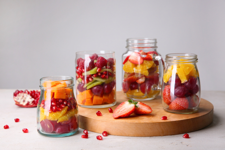 Glassware with delicious fruit salads on tableの写真素材
