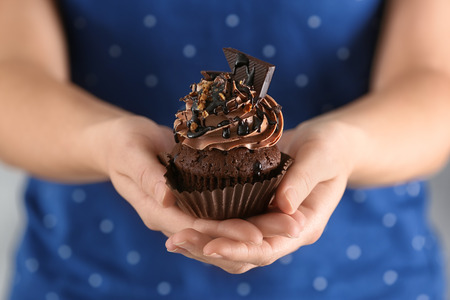 Woman holding tasty chocolate cupcake, closeupの写真素材