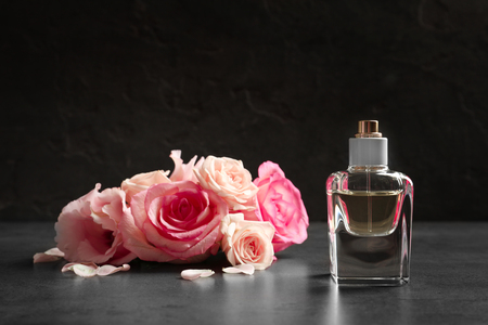 Bottle of perfume with flowers on dark backgroundの写真素材