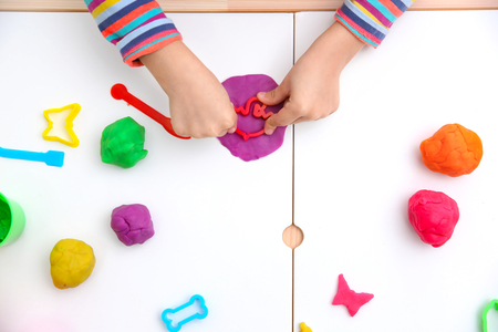 Little girl engaged in playdough modeling at table, top viewの写真素材