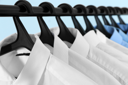 Clean shirts hanging on rack in laundry, closeupの写真素材