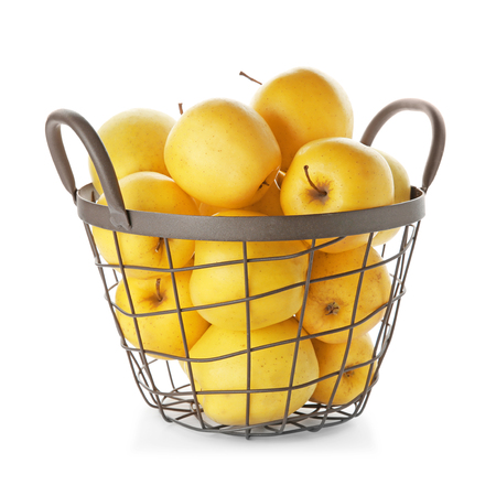 Metal basket with ripe yellow apples on white backgroundの写真素材