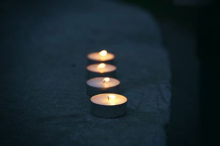 Burning candles on cement outdoorsの写真素材