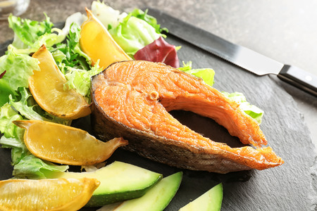 Tasty rainbow trout steak with garnish on slate plate, closeupの写真素材