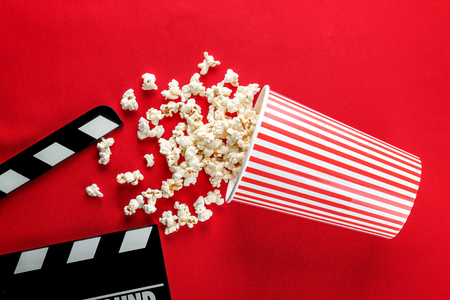 Popcorn and movie clapper on color backgroundの写真素材