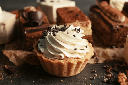 Tasty tartlet with whipped cream on table