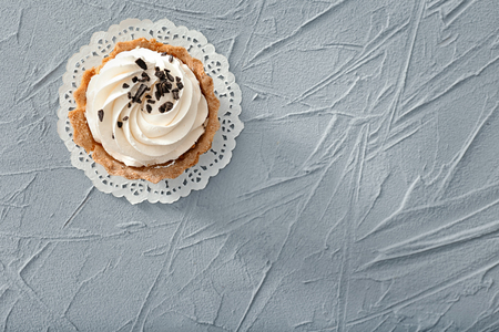 Tasty tartlet with whipped cream on textured background, top viewの写真素材