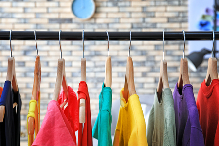 Rack with rainbow clothes indoorsの写真素材