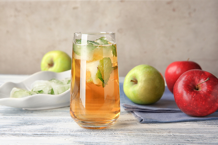 Apple juice with ice cubes and mint on tableの写真素材