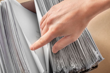 Woman searching for documents in archive, closeup