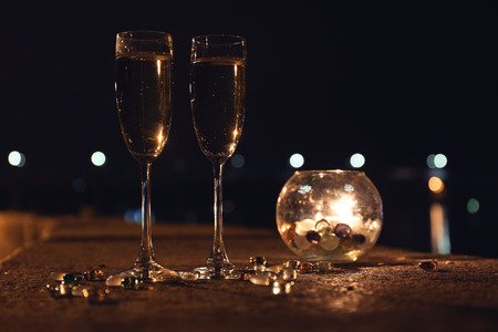 Romantic composition with burning candle and glasses of champagne at night, outdoorsの写真素材