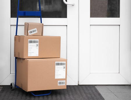 Postal cart with delivered parcels near front doorの写真素材