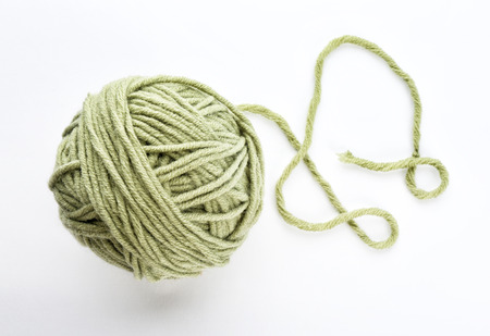 Green yarn ball on white background