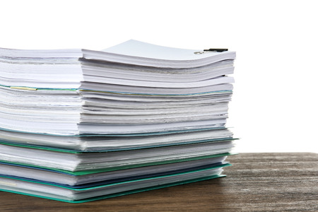 Stack of documents on table against white backgroundの写真素材