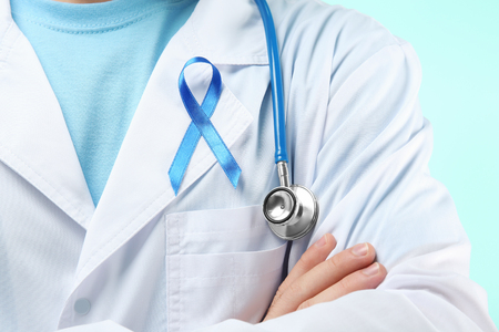 Doctor with symbolic blue ribbon, closeup. Cancer awareness conceptの写真素材