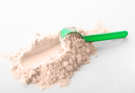 Measuring scoop and protein powder on white backgroundの写真素材