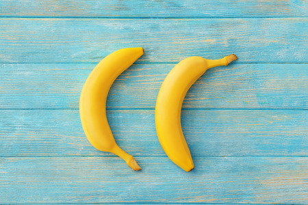 Tasty ripe bananas on color wooden backgroundの写真素材