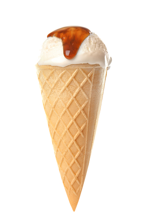 Waffle cone with ice cream and caramel sauce on white backgroundの写真素材