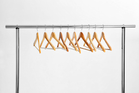 Wardrobe stand with hangers on light backgroundの写真素材