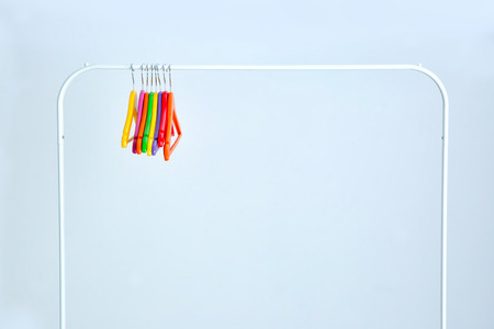 Wardrobe stand with hangers on light backgroundの写真素材