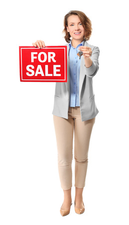 Beautiful real estate agent with "For sale" sign and key on white backgroundの写真素材