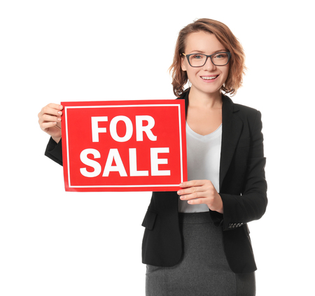 Beautiful real estate agent with "For sale" sign on white backgroundの写真素材