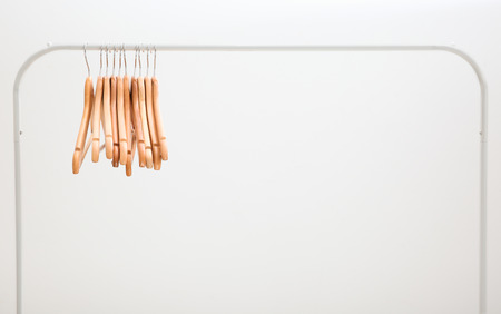 Wardrobe stand with hangers on light background