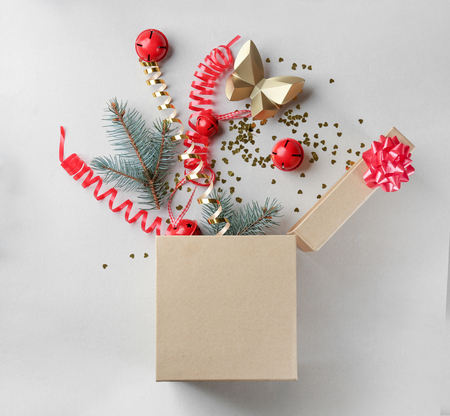 Opened gift box with fir branches and Christmas decorations on light background, top viewの写真素材