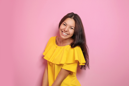 Attractive young woman posing on color backgroundの写真素材