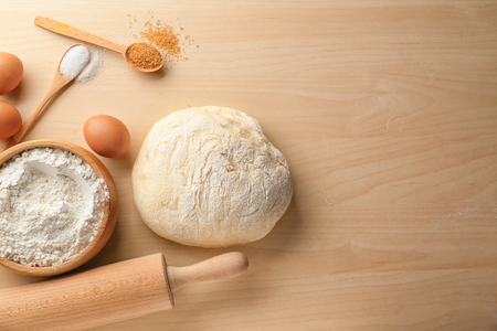 Fresh raw dough with ingredients on wooden tableの写真素材