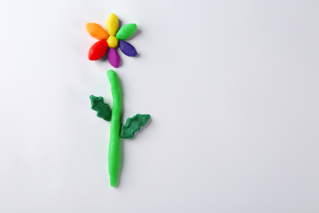 Rainbow flower made from play dough on white backgroundの写真素材