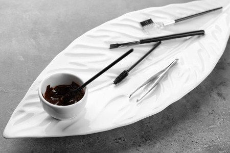 Set of tools for eyebrow dyeing and correction on plateの写真素材