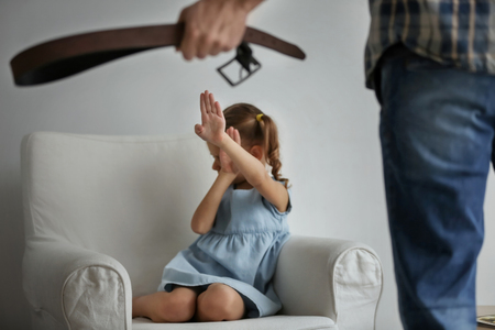 Man threatening his daughter at homeの写真素材