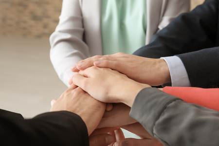 Group of people putting hands together as symbol of unityの写真素材