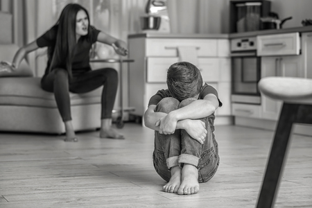 Woman scolding her son at home, black and white effectの写真素材